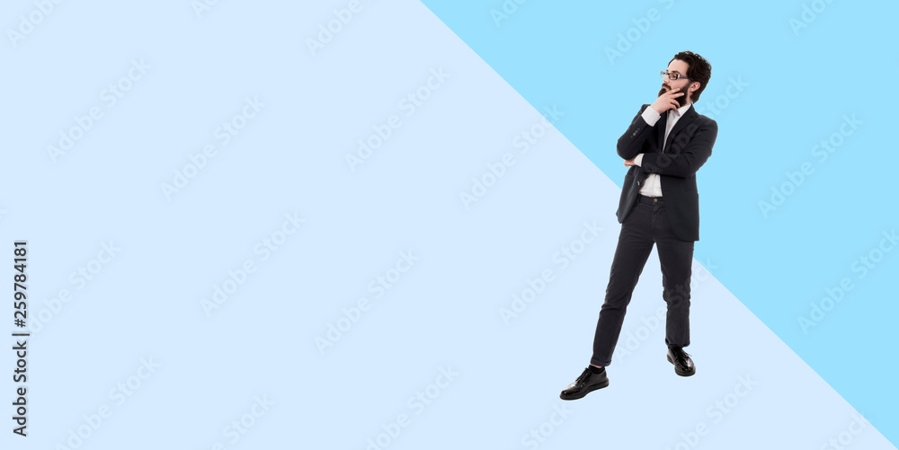 full length portrait of  thinking bearded businessman, panoramic photo with copy space