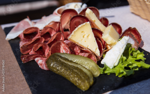 Detail of a plate of speck and typical italian salami with cheese and pickles, Cortina D'Ampezzo, Italy