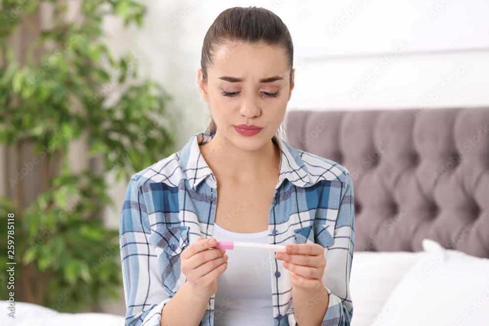 Young woman with pregnancy test at home. Gynecology and childbirth Young woman with pregnancy test at home. Gynecology and childbirth