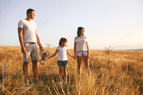 Happy family playing on nature in summer at sunset.