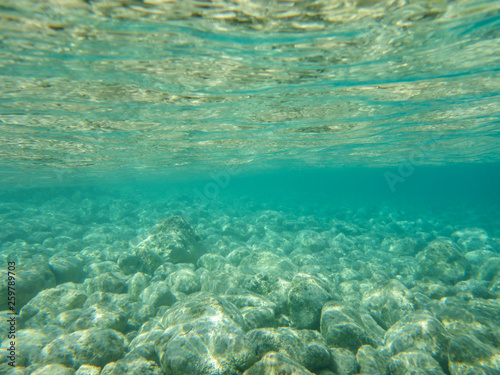 UNDERWATER view of turquoise clear water and white pebbles scattered off the seabed of the Antisamos bay  Kefalonia island  Ionian Sea  Greece.