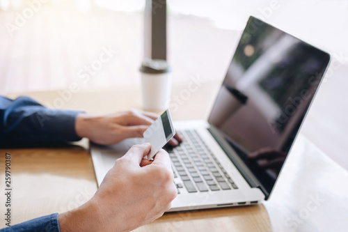 Businessman holding credit card and typing on laptop for online shopping and payment makes a purchase on the Internet, Online payment, Business financial and technology