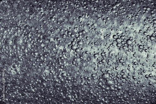Silver metallic paint over bumpy surface, abstract texture photo.