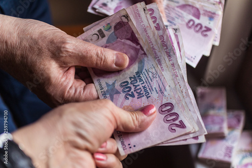 man is giving woman 200 Turkish lira banknots