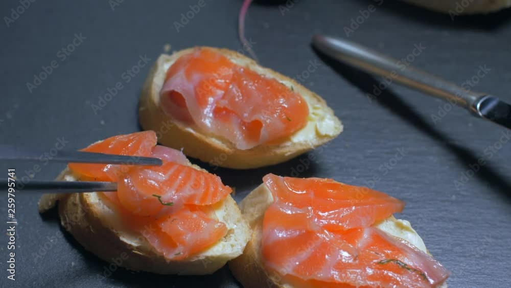 Putting salmon on a slice of butter. Slow motion Putting salmon on a slice of butter. Slow motion