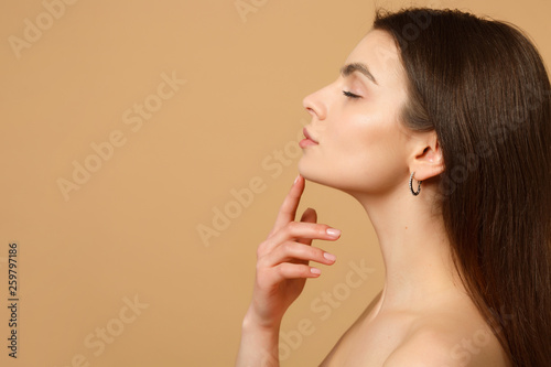 Close up brunette half naked woman 20s with perfect skin, nude make up isolated on beige pastel wall background, studio portrait. Skin care healthcare cosmetic procedures concept. Mock up copy space. photo