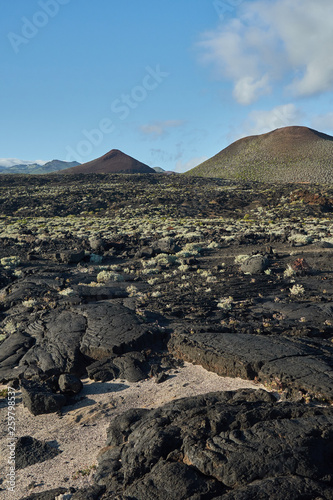 Black textured rough cliff with mountain on the background