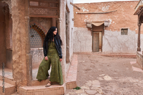 Young lady standing near retro building on street in Marrakesh, Morocco photo