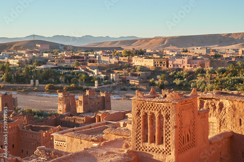 From above old town with stone constructions near narrow river between desert and beautiful heaven with clouds in Marrakesh, Morocco photo