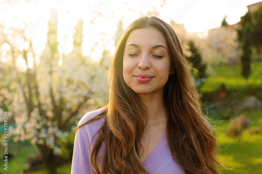 Woman smiling with closed eyes taking deep breath celebrating freedom. Positive human emotion face expression feeling life perception success peace mind concept. Free Happy girl enjoying nature.