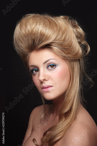 Young beautiful woman with vintage style prom hairdo and fancy makeup