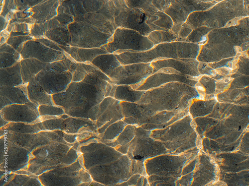 Light stained sea bottom shot through the water surface