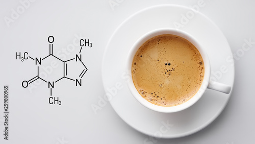 Cup of fresh coffee on white background. Blackboard with the chemical formula of Caffeine. Top view with copyspace photo