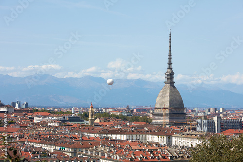 Turin city rooftops  Mole Antonelliana tower and hot air balloon in a sunny summer day in Italy