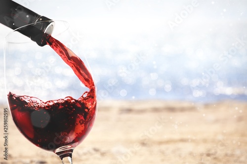 Red wine being poured in wineglass, closeup