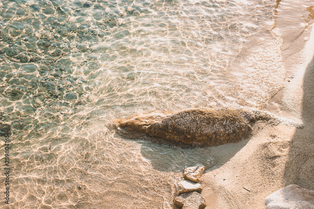 summer vacation and rest concept photography aerial shot wild sand beach with single stone near blurred from the sun coast water surface , Instagram toning fashion style