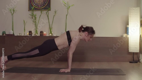 Crane shot. Strong attractive woman performing yoga asana. Mayurasana. photo