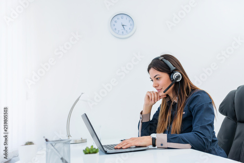 Businesswoman working on a laptop with headset on
