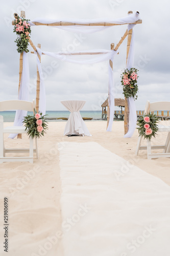 Dekoration einer Hochzeit mit Stuehlen am Strand mit Meer im HIntergrund