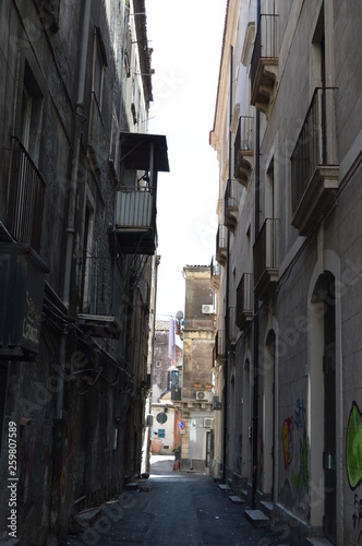 Narrow street in old town with graffiti, Sicily, Italy