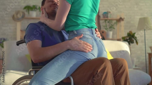 Close up romantic relationship between a young girl and a disabled person in a wheelchair