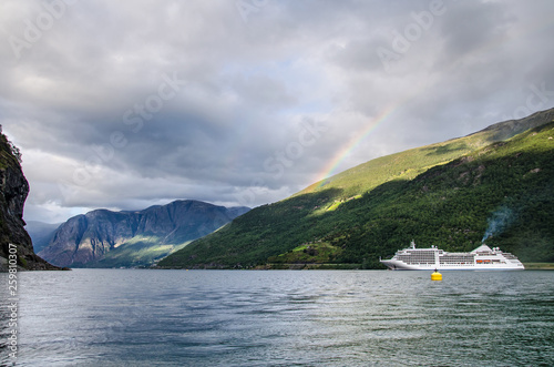 Sailing ship on a Norway fjord with mountains behind and rainbow and clouds above © Czech the World