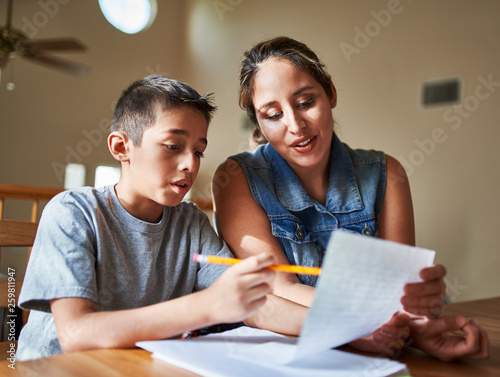 mother helping son with homework photo