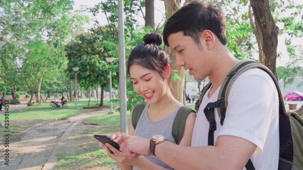 Traveler Asian couple direction on location map in Bangkok, Thailand, couple using mobile phone looking on map find landmark while spending holiday trip. Lifestyle couple travel in city concept. Traveler Asian couple direction on location map in Bangkok, Thailand, couple using mobile phone looking on map find landmark while spending holiday trip. Lifestyle couple travel in city concept.