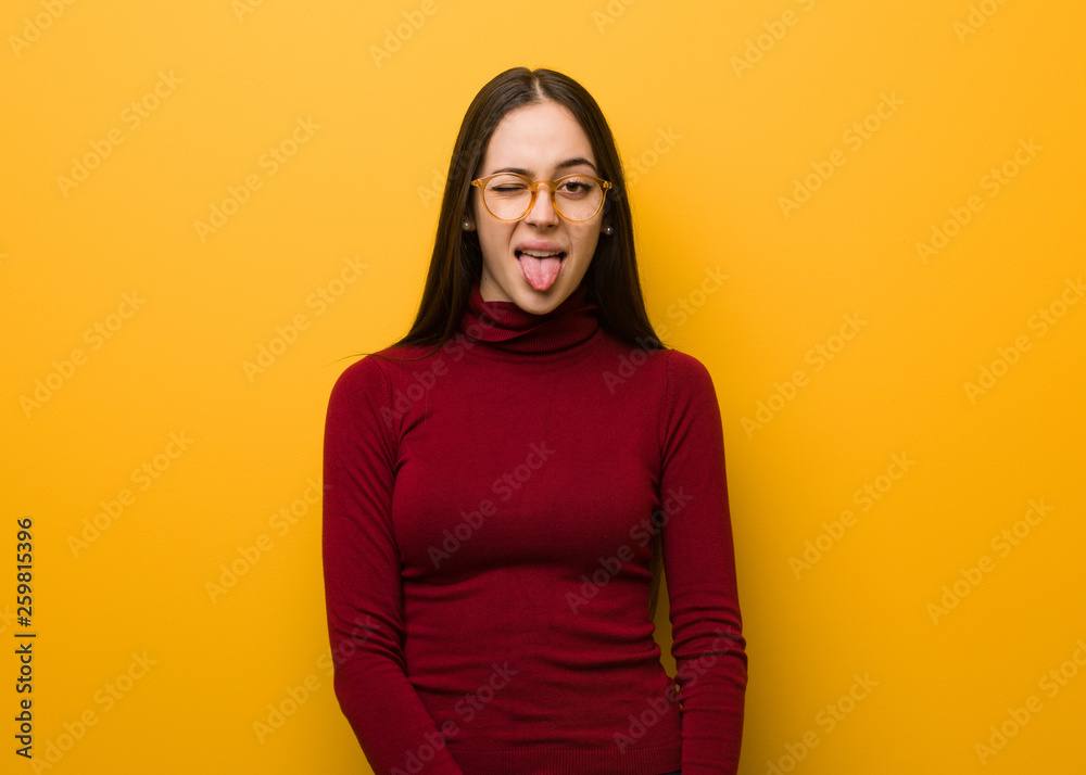 Fototapeta premium Intellectual young girl funnny and friendly showing tongue