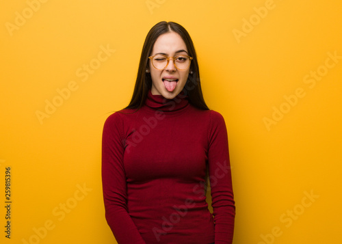Intellectual young girl funnny and friendly showing tongue © Asier