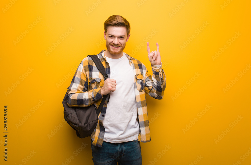 Young redhead student man doing a rock gesture Young redhead student man doing a rock gesture