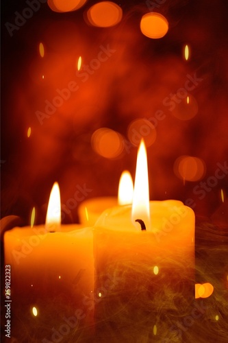 Candles light. Christmas candles burning at night. Abstract candles background. Golden light of candle flame.