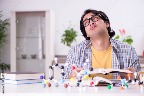 Young student physicist preparing for exam at home 