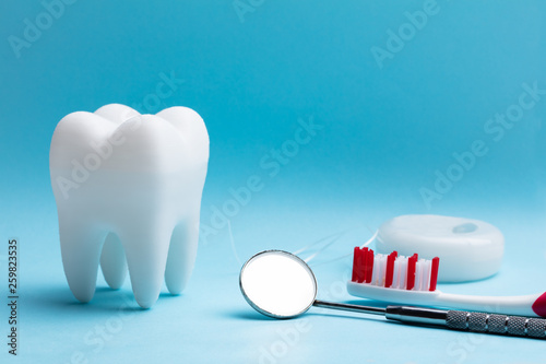 Artificial Tooth And Dental Equipment On Blue Background