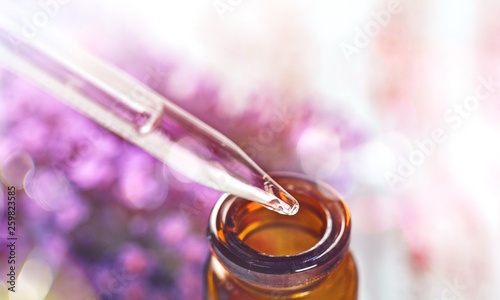 Pile of lavender flowers and a dropper bottle with lavender essence