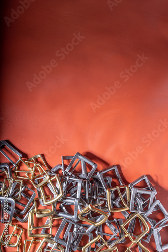 Belt buckles on red full grain leather background. Materials  accessories on leather craftman s work desk