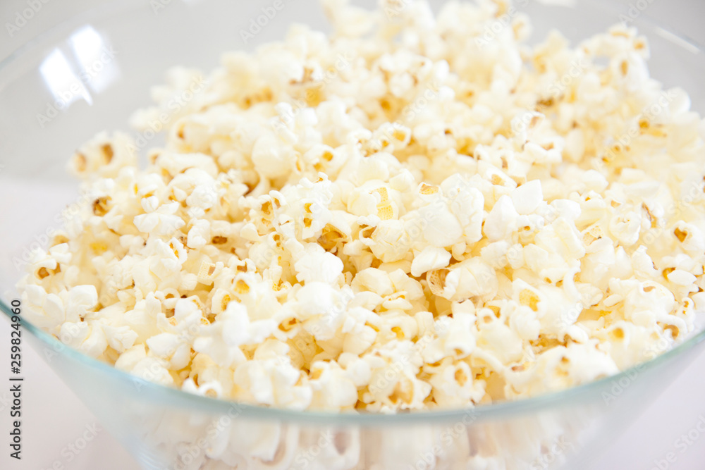 Clear plastic or glass dish filled with fresh popcorn Clear plastic or glass dish filled with fresh popcorn