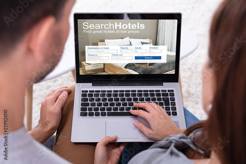 Couple Searching Hotels On Laptop
