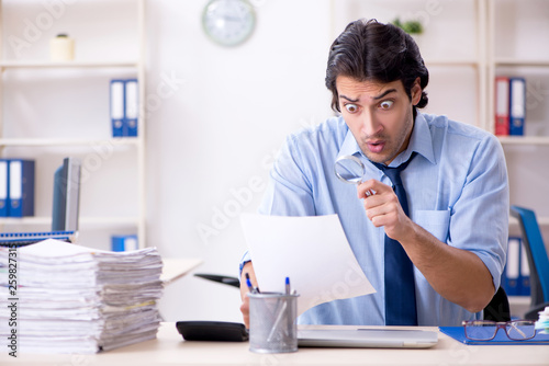 Young male businessman employee unhappy with excessive work 