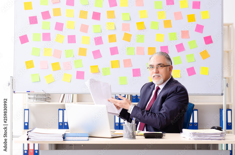 Naklejka premium Aged man employee in conflicting priorities concept 