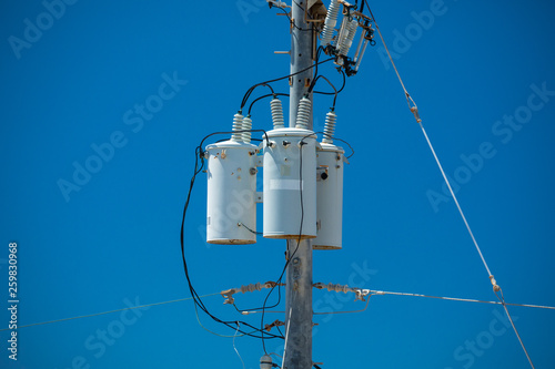 Electric pole with a transformer and wires photo