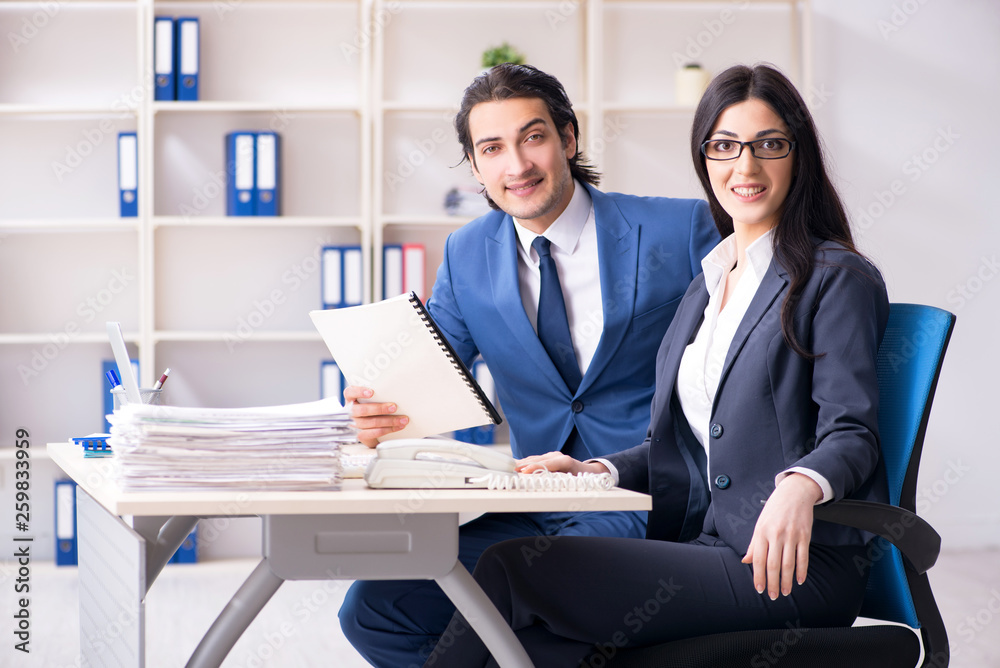 Two employees working in the office Two employees working in the office