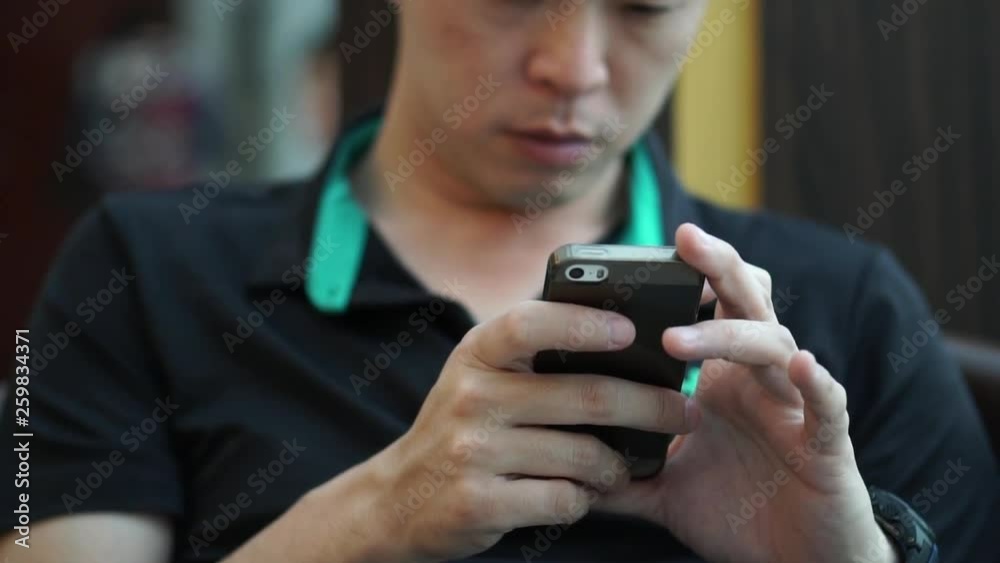Asian man working online through smartphone Asian man working online through smartphone
