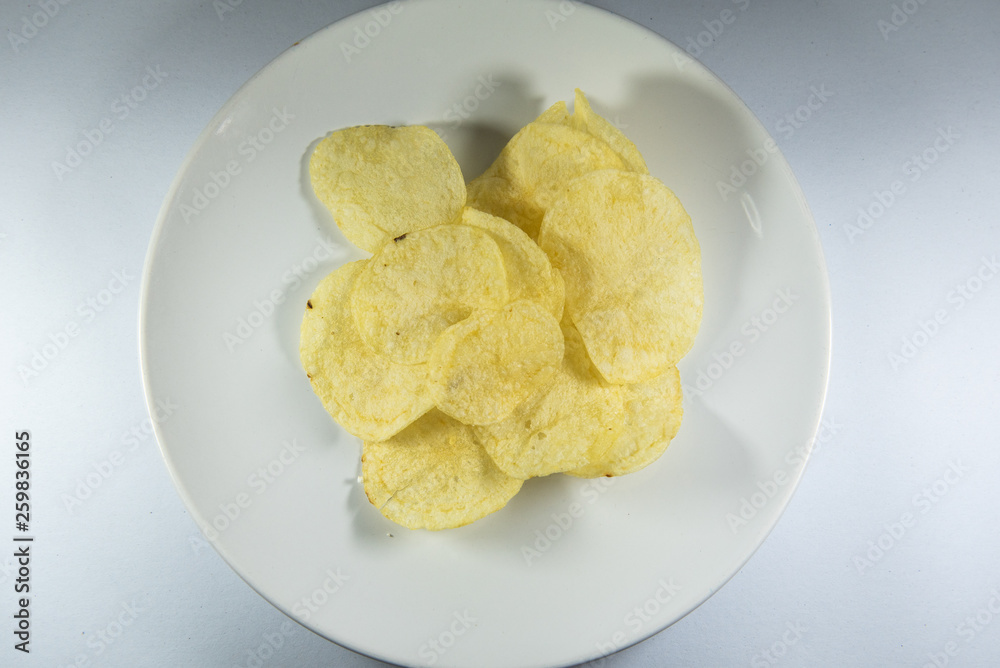 Potato chips in a plate on white background Potato chips in a plate on white background