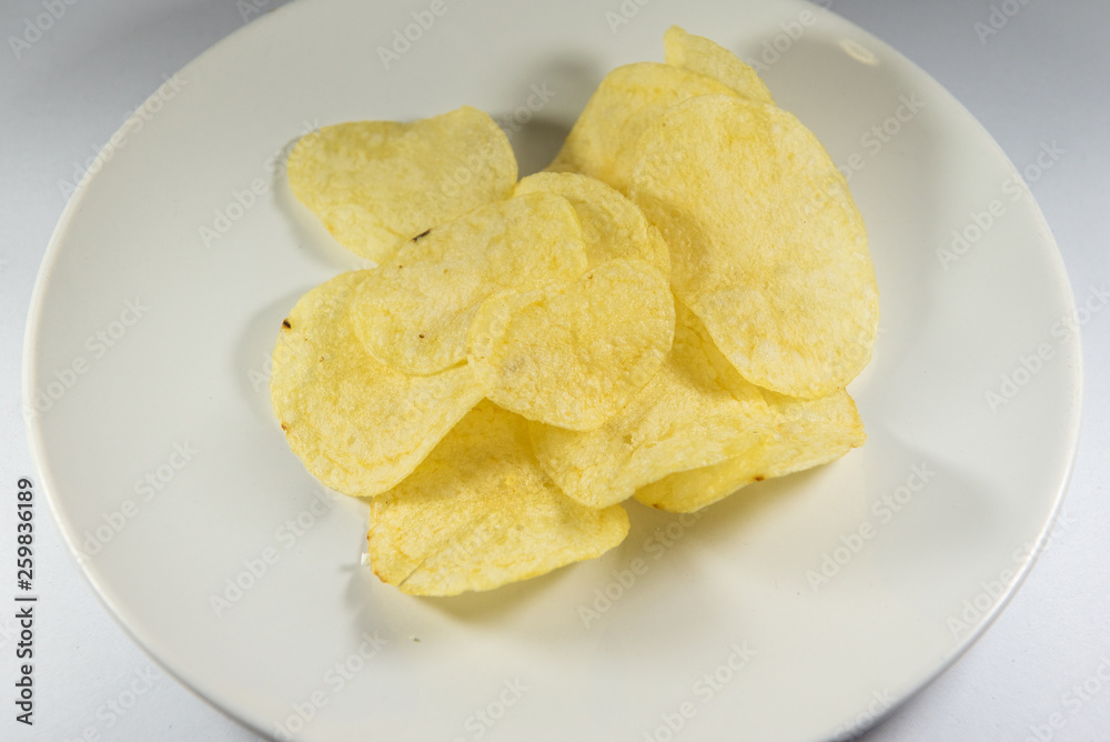 Potato chips in a plate on white background Potato chips in a plate on white background