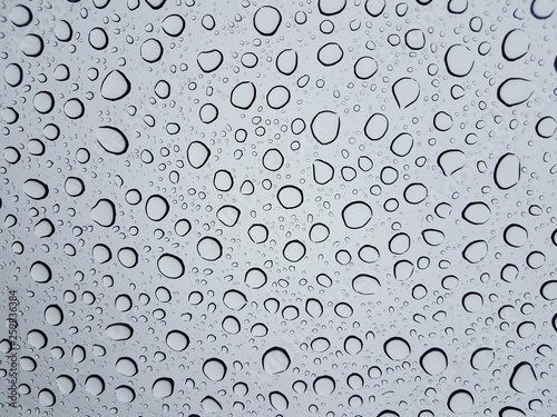 circular water droplets or drops on glass window from rain