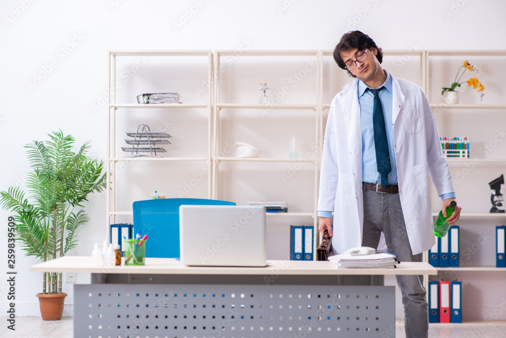 Young male doctor drinking in the office Young male doctor drinking in the office