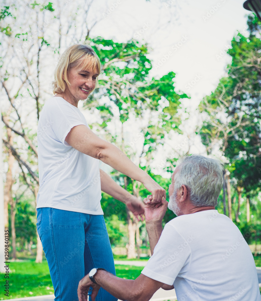 Fototapeta premium Happy old man kiss his wife hand at the park