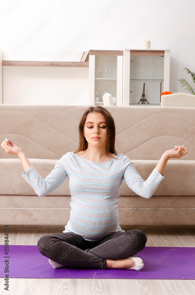 Young pregnant woman doing sport exercises at home Young pregnant woman doing sport exercises at home
