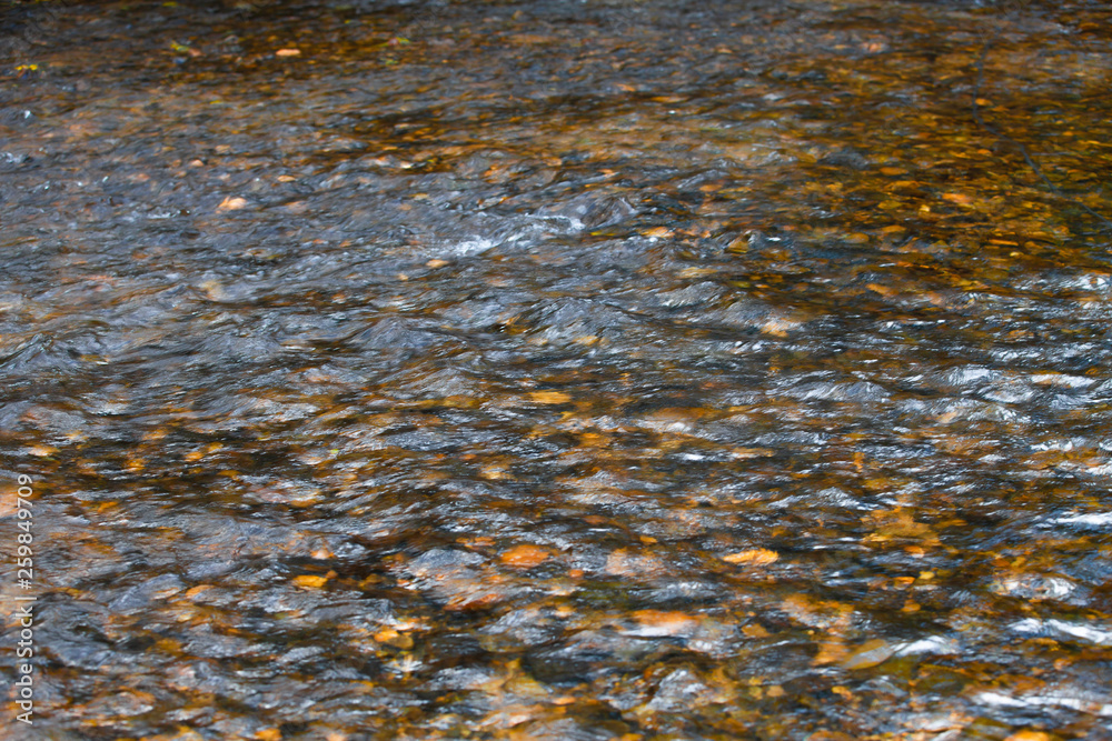 The reflection of the water surface with natural brown stones on the bottom is a lot of background.soft focus.